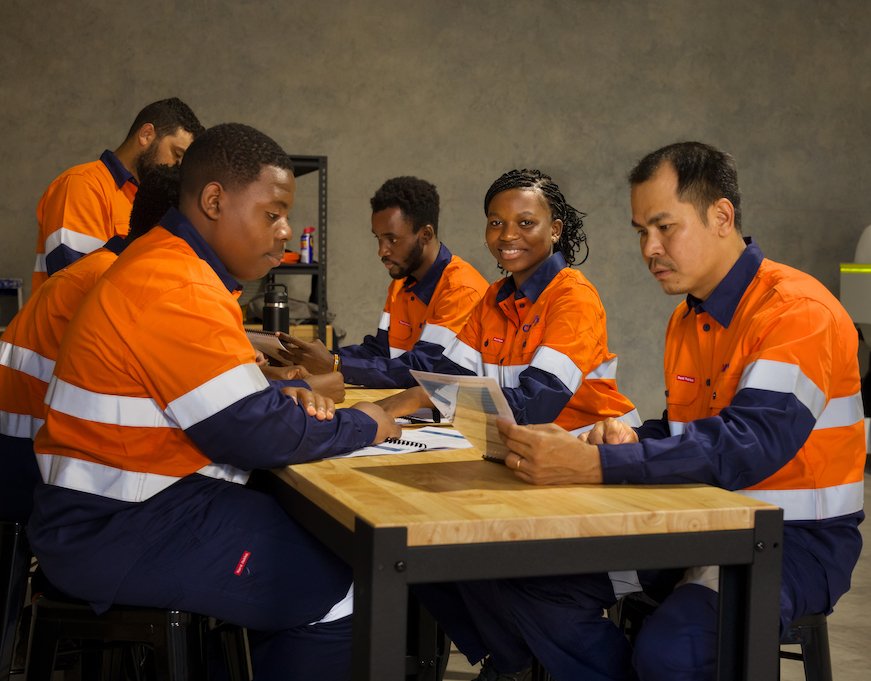 Group of Civik workers sitting around a table. Julienne is looking directly at the camera